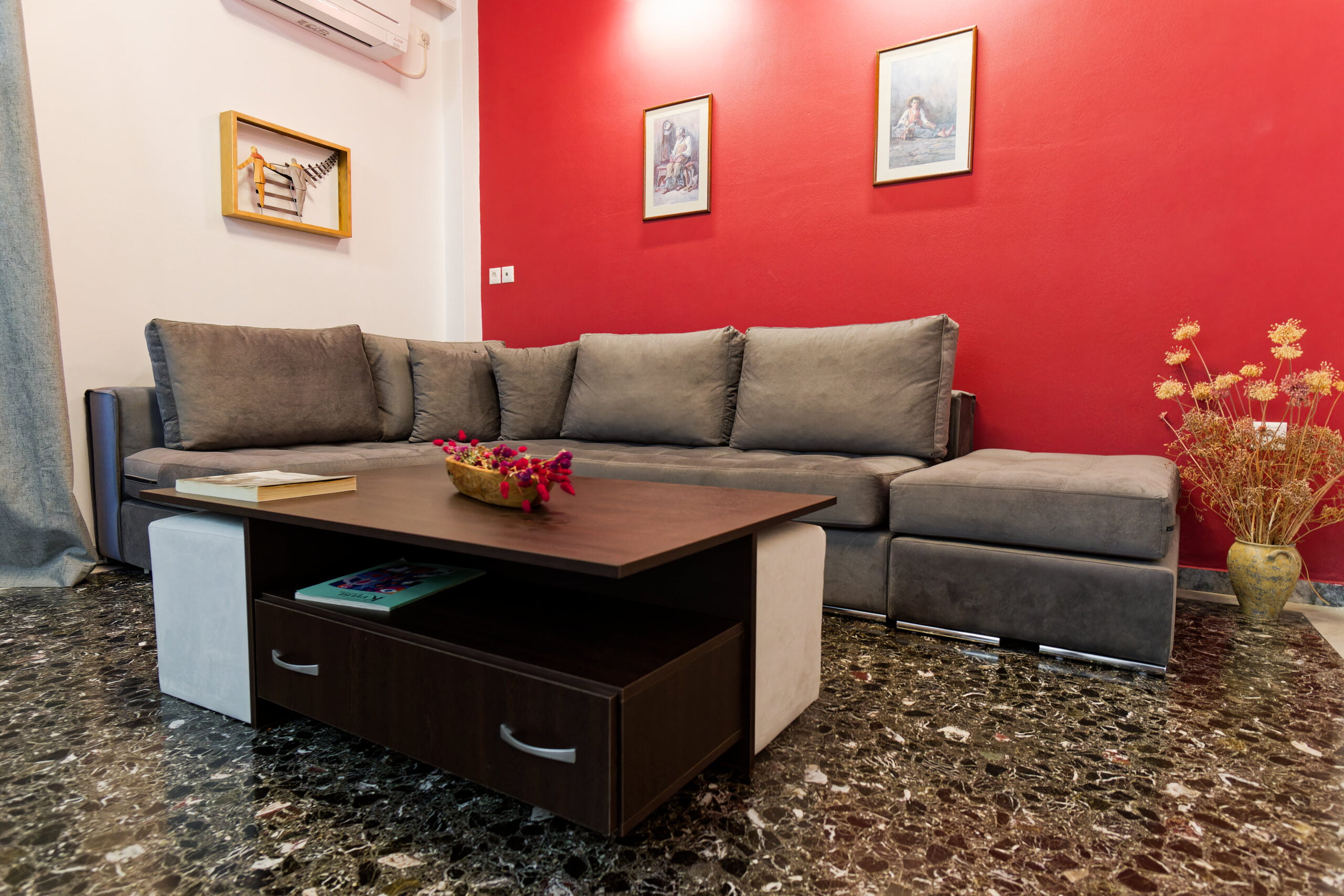 Cozy lounge with grey sectional sofa and red accent wall